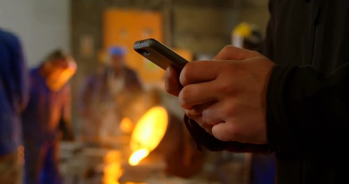 Male worker using mobile phone in workshop