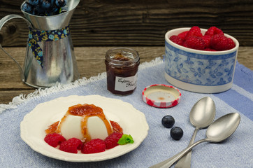 Tasty panna cotta with fresh fruits and raspberry sauce