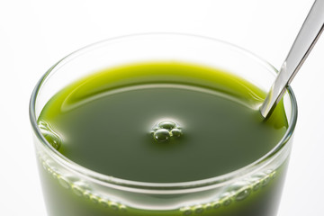 透明のグラスに青汁のアップ