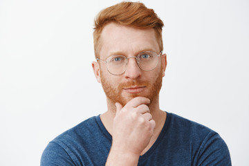 Headshot of creative and smart handsome redhead guy with bristle in glasses and blue t-shirt,...