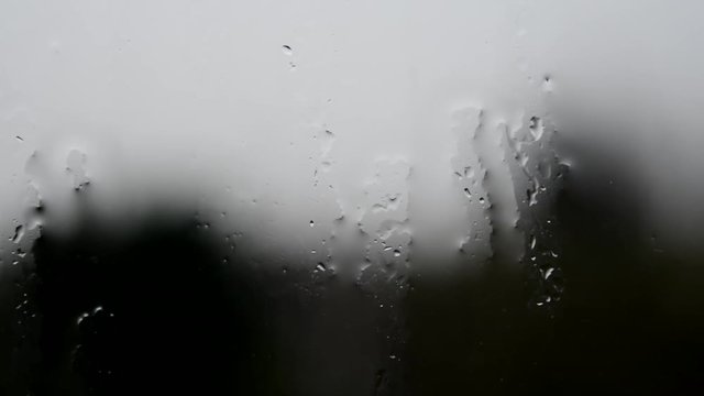 Raindrops on the window after a big rainstorm on a dark midday winter