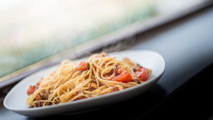 Quick dinner idea - takes 15 minutes - Italian spaghetti pasta with herbs, tomatoes and black pepper served on white plate