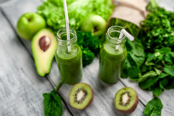 smoothie with vegetables, avocado, apple, kiwi on a wooden background. sports nutrition