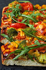 Vegan pizza with vegetables and fresh arugula.