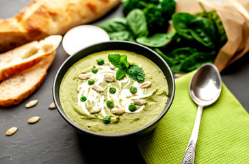 Green cream soup of spinach and broccoli. concrete or slate background. The concept of a healthy diet and diet.