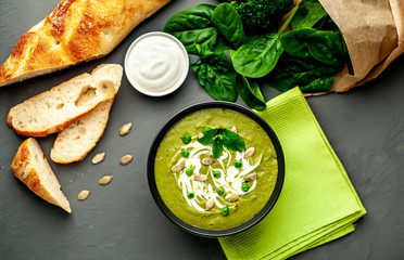 Green cream soup of spinach and broccoli. concrete or slate background. The concept of a healthy diet and diet.