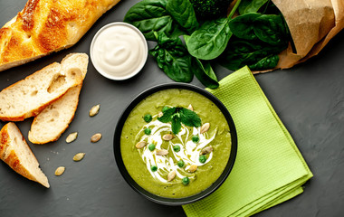 Green cream soup of spinach and broccoli. concrete or slate background. The concept of a healthy diet and diet.
