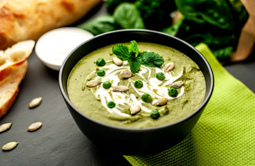 Green cream soup of spinach and broccoli. concrete or slate background. The concept of a healthy diet and diet.