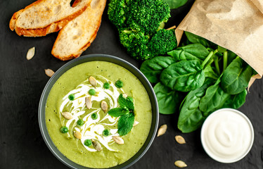 Green cream soup of spinach and broccoli. concrete or slate background. The concept of a healthy diet and diet.