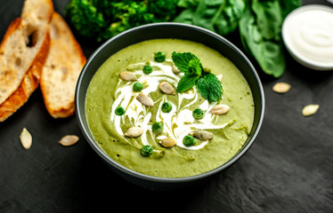 Green cream soup of spinach and broccoli. concrete or slate background. The concept of a healthy diet and diet.
