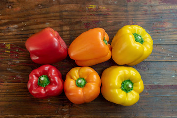 Top view of colorful bell peppers on distressed wooden table