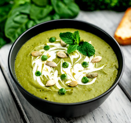 Green cream soup of spinach and broccoli. wooden background. The concept of a healthy diet and diet.