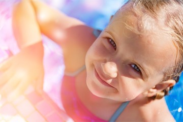 Beautiful little girl swimming at the pool