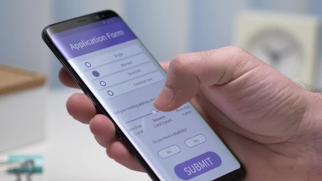 User filling an application form on his smartphone screen. Closeup on the device.