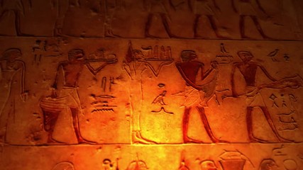 Ancient Egyptian artwork inside tomb of the pyramids lit by candle ALT