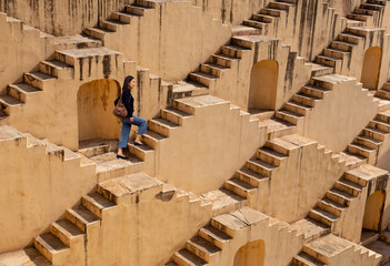 Woman walking on step wells of Chand Baori in Jaipur India.