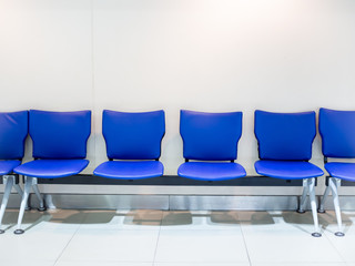 Empty blue leather airport seats on white background