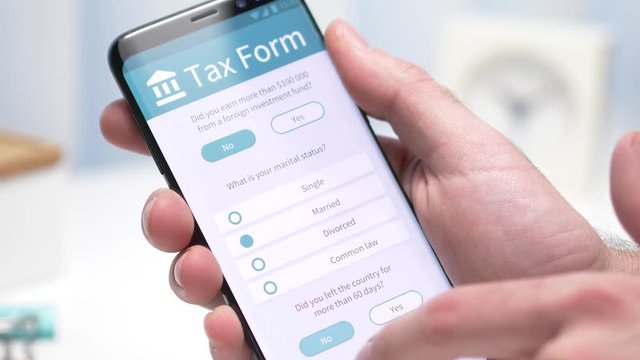 User filling an tax form on his smartphone screen. Closeup on the device.