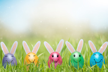 Easter holiday concept with cute handmade eggs, bunnies on the lawn. Banner for design