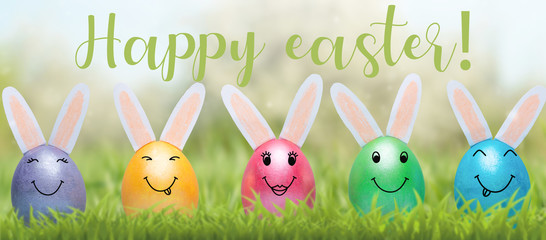 The concept of Easter holiday with cute handmade eggs, rabbits on the lawn. With the inscription happy Easter!