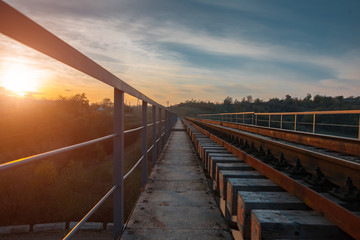 Naklejka premium Landscape of railway track over background of colorful sunset.