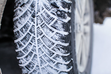 Close up car tires covered with snow. Winter tyres in extreme cold temperature.
