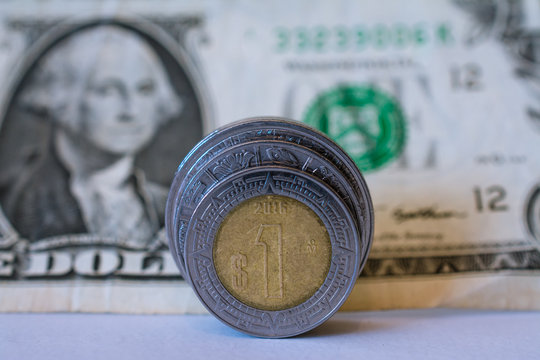 El peso y un dolar americano enrollado.