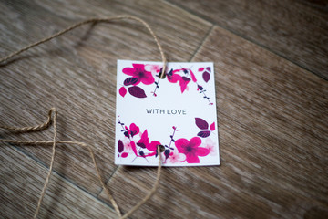 The card with florets and the inscription "With love", lies against the background of, tied up by a rope
