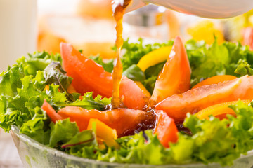 野菜サラダにドレッシングをかける