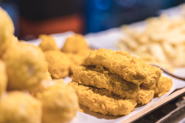 Fried chicken knead with bread then fry to get gold color, and other junk food on background