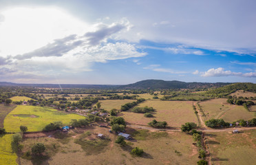 Naklejka premium Vista Aérea de Campo con Casas y Montañas