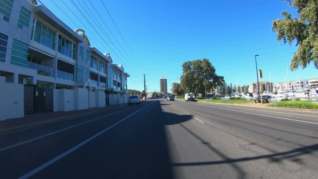 Vehicle POV driving past the Marina in Glenelg, seaside suburb of Adelaide South Australia.