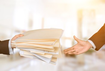Hands of businessmen holding documents on background