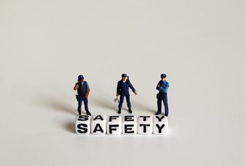 SAFETY text written in white cube and miniature combat police.