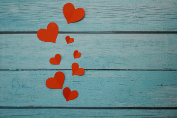 Red paper hearts on a blue wooden background