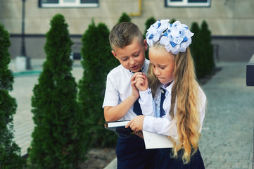 Primary school students near the school . The children do their homework on the street