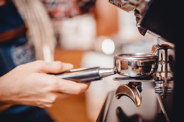 Fototapeta na wymiar Hands baristas holding fine grinding of coffee for espresso.