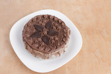 Chocolate cake top view on wooden background table. Sweet dessert.