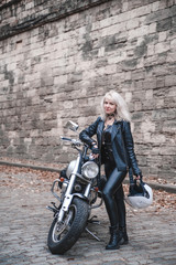 Obraz na płótnie Canvas Beautiful biker woman posing outdoor with motorcycle.