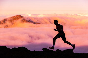 Trail runner athlete man running in nature landscape. Silhouette of male person training on...