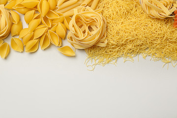 Assortment of uncooked pasta on light background