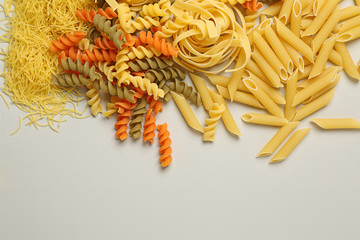 Assortment of uncooked pasta on light background