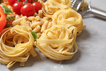 Raw pasta on grey background