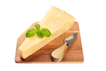 A piece of aged Parmesan cheese with fresh basil leaves and a cheese knife, isolated on a white background with a clipping path