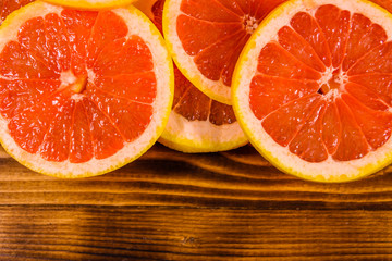 Sliced juicy grapefruit on a wooden table. Top view