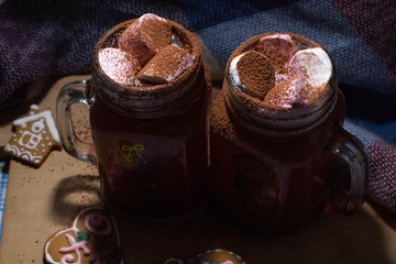 Mugs with chocolate and sweet marshmallow  on a wood desk with different lights