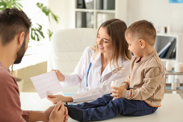 Young father with his little son visiting doctor in clinic