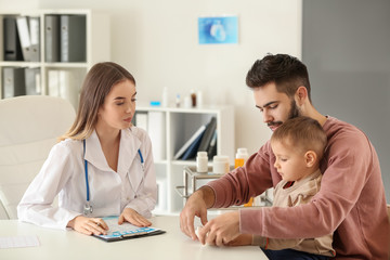 Obraz premium Young father with his little son visiting doctor in clinic