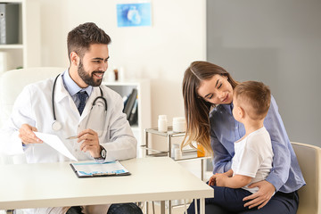 Obraz premium Young mother with her little son visiting doctor in clinic
