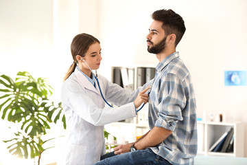 Fototapeta premium Female doctor working with male patient in clinic